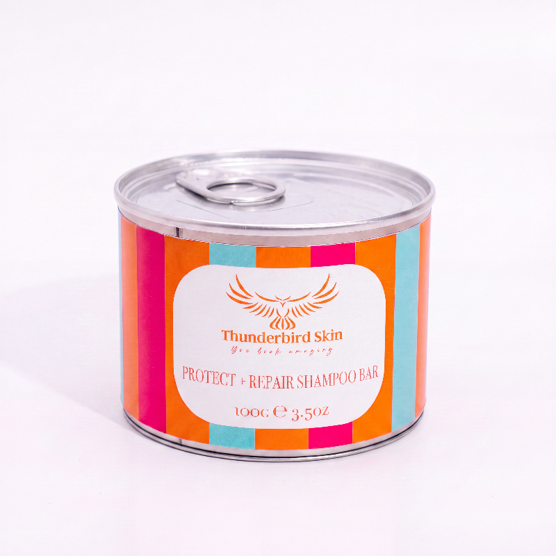 A 100g can of Thunderbird Skin Protect + Repair Shampoo Bar, featuring a colorful striped label with orange, pink, and teal on a white background.