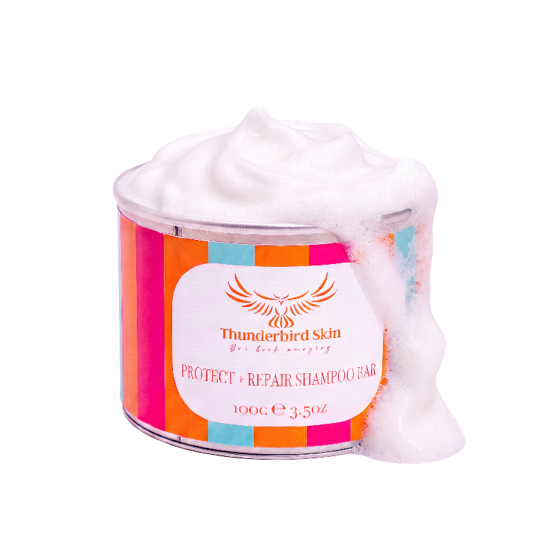 A tin of Thunderbird Skin Protect + Repair Shampoo Bar, filled with white shampoo bar and overflowing with thick white foam, set against a solid white background.