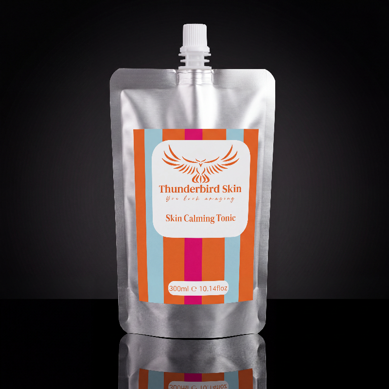 A 300ml silver foil pouch of Thunderbird Skin Skin Calming Tonic with a white cap, set against a dark reflective background.