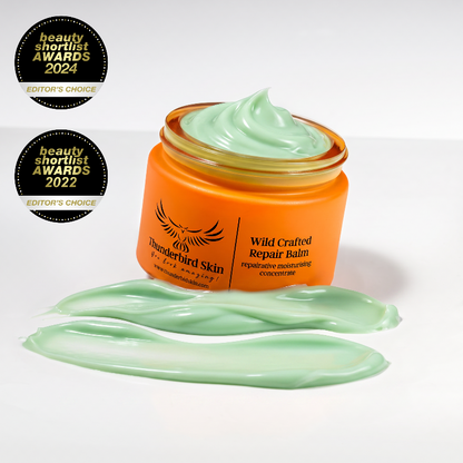 An open jar of Thunderbird Skin Wild Crafted Repair Balm with pale green balm cream visible inside and in front, set on a white background with two black beauty shortlist award badges on the left.